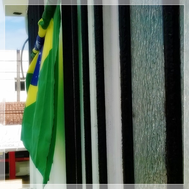 Penduramos a bandeira na janela no primeiro dia de jogo, mas agora ela está assim, um pouco enrolada (parece um pouco com a seleção, né? rs).
